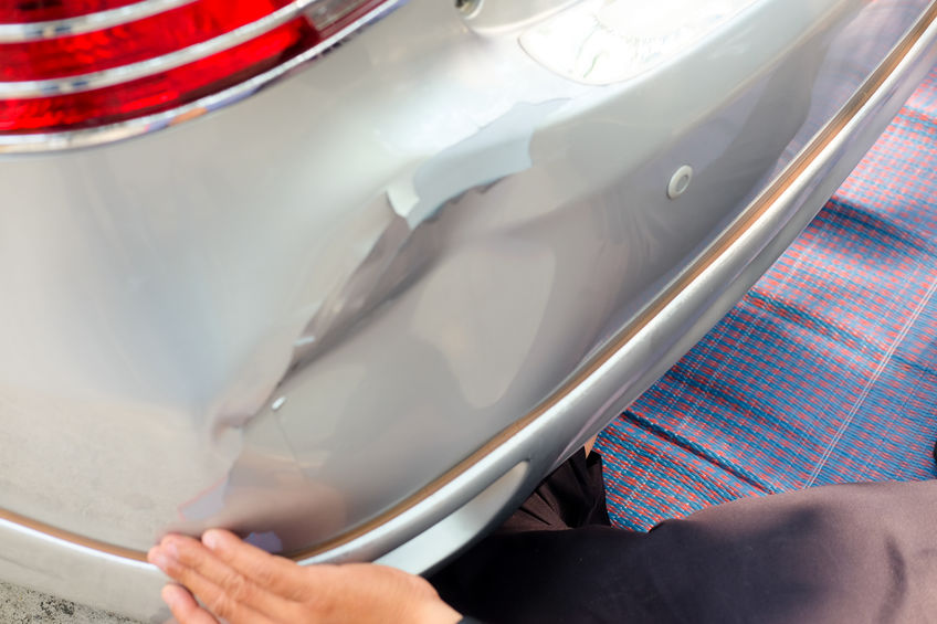 Small dent in rear bumper on silver car
