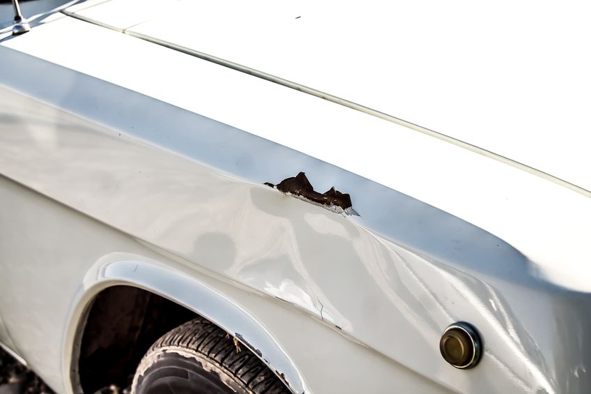 dent and scratch on the wing of a car